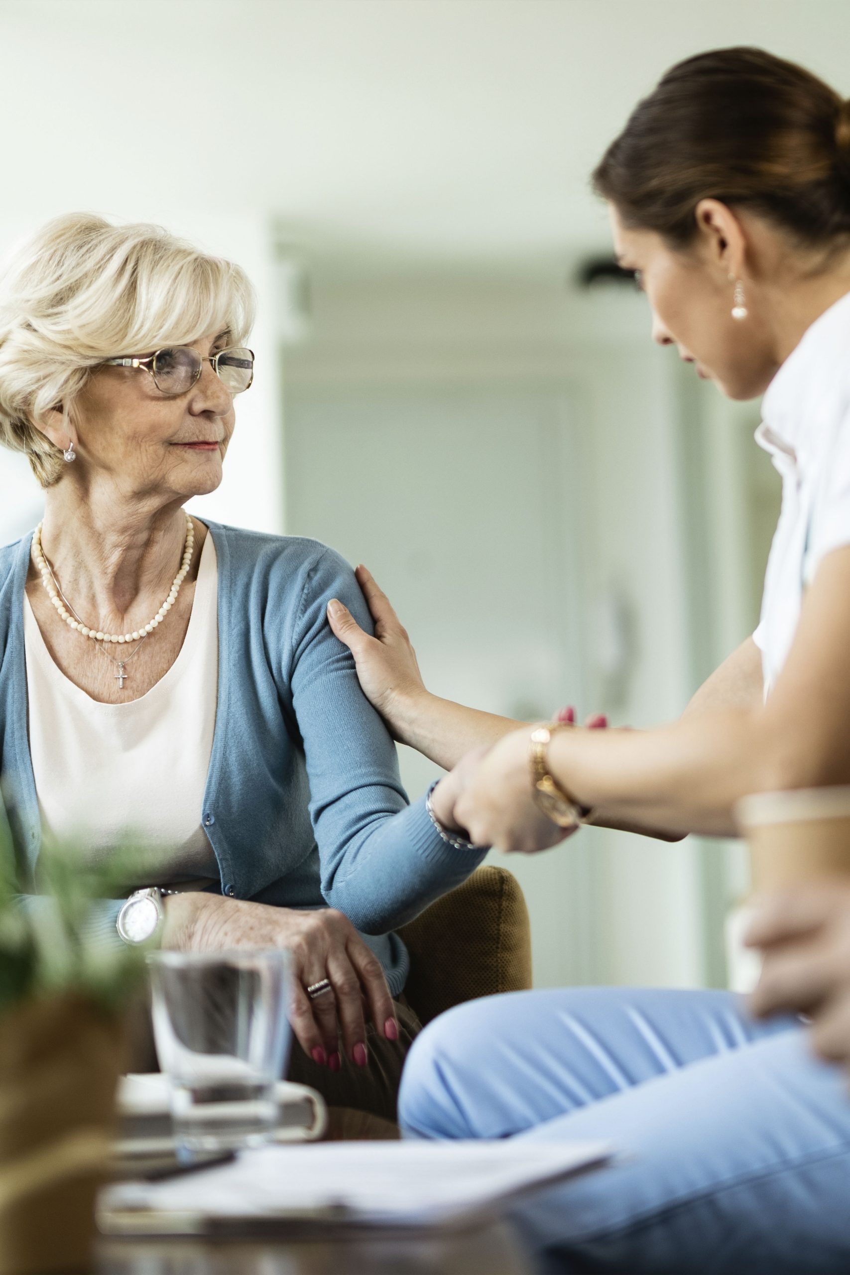 female-nurse-communicating-with-senior-woman-while-being-home-visit-focus-is-senior-woman