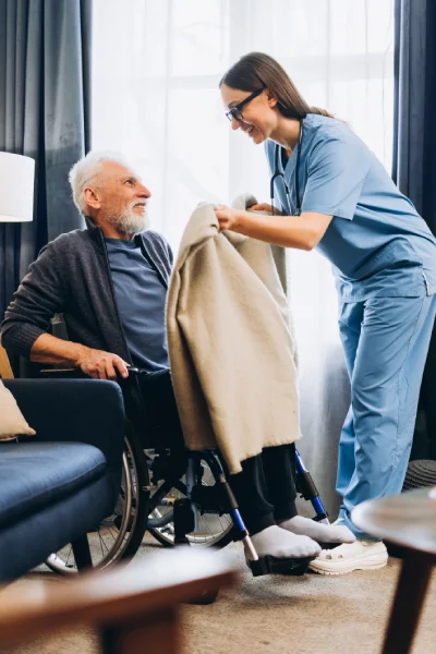 assistedlivngmid Loving caregiver putting warm blanket on memory care resident in Conroe