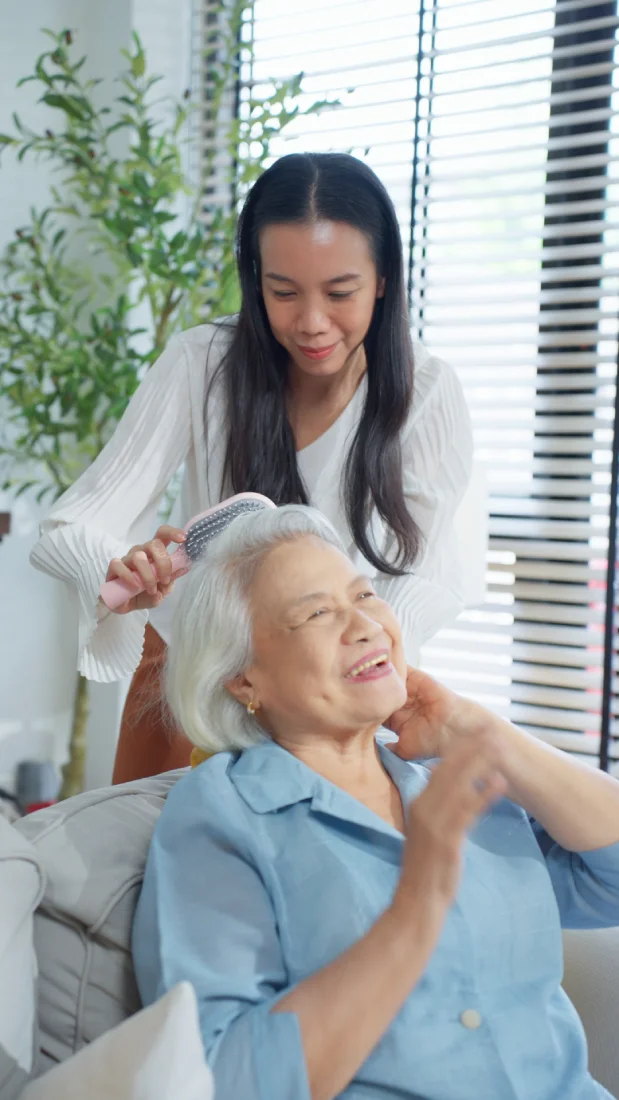 botique senior care avl Happy caregiver brushing smiling seniors hair in Conroe